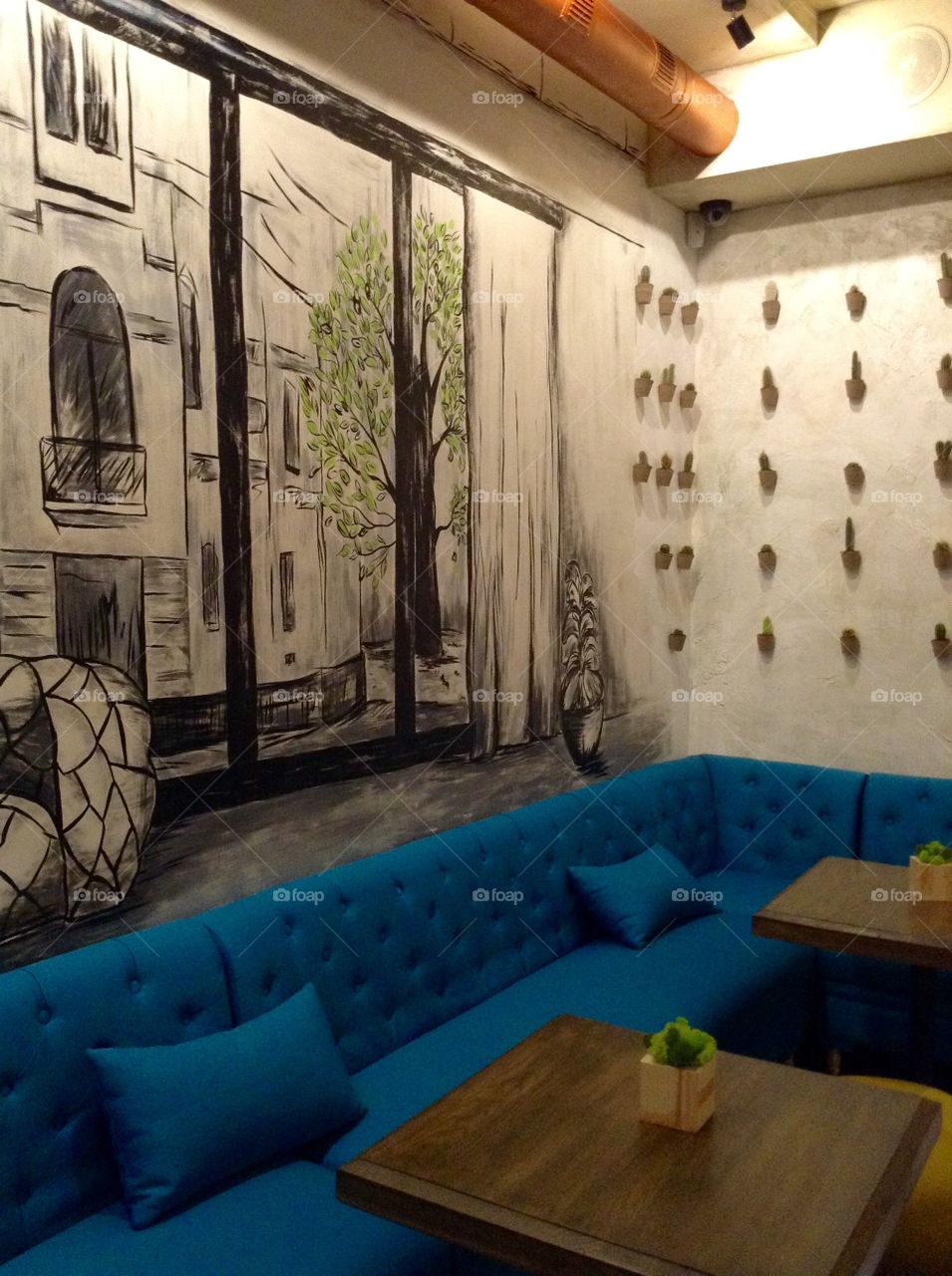 Blue sofa and a drawing on the wall in a coffeeshop 