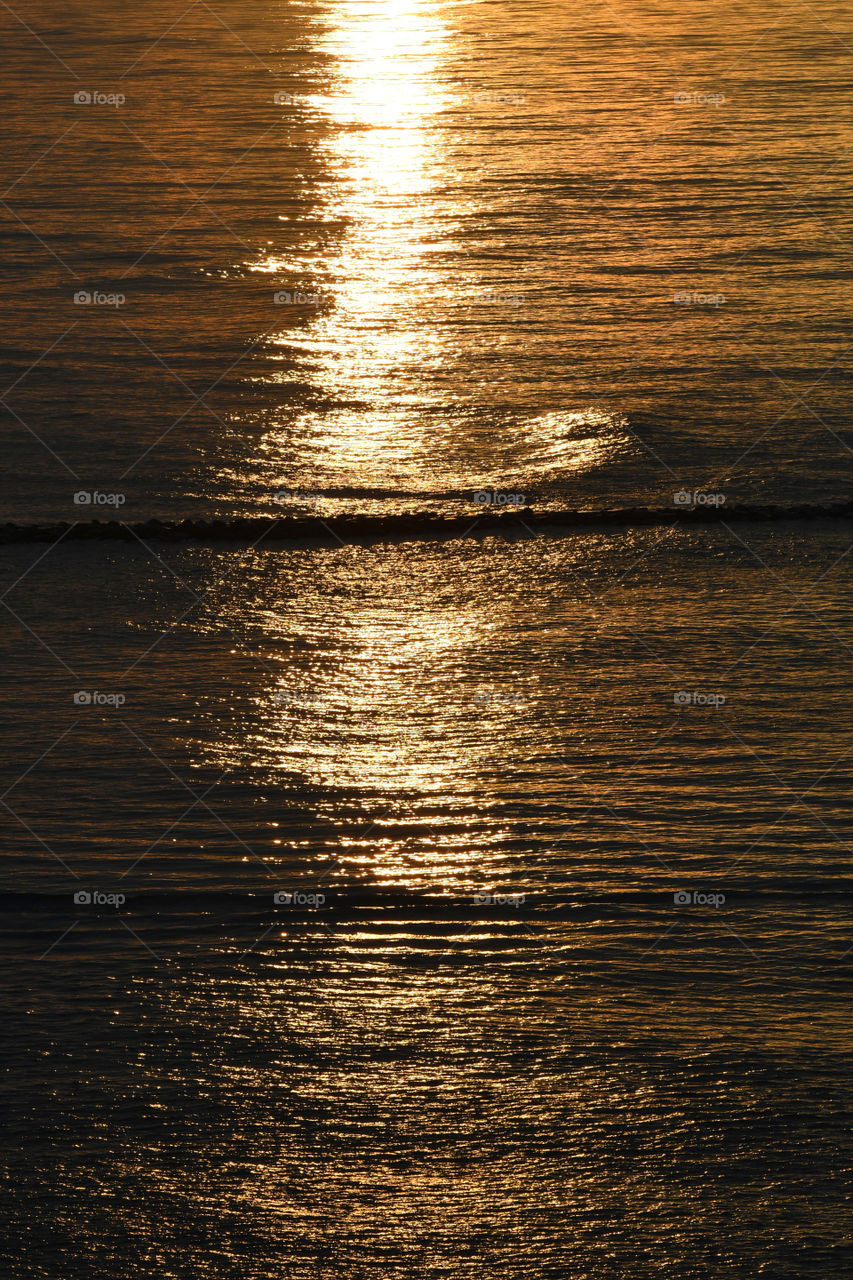 Radiant sunlight from a sunrise off the Absecon bay in Atlantic city illuminates and reflects on the vast oceanfront.