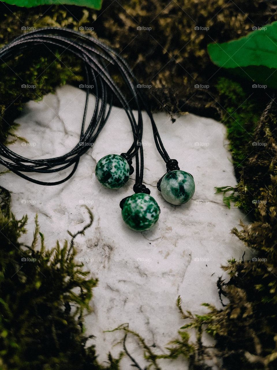 Green moss agate round beaded chockers on cord close up, jewelry, gemstone texture