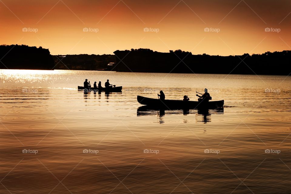 People in canoes on a lake in the summer