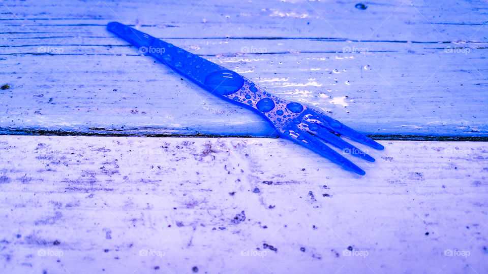 Forgotten little fork on a wet table by a café