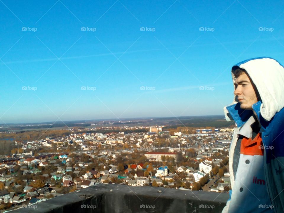 a man on a rooftop view of the city