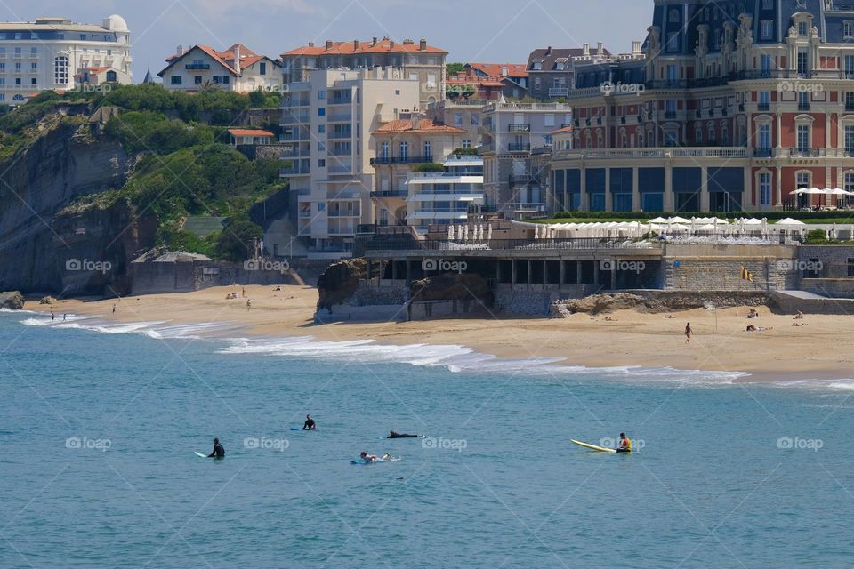 Wide angle view of sea and beach by buildings. 