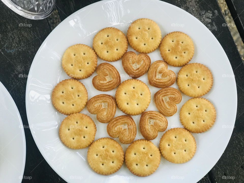 A plate full of salted and little heart cookies arranged in a beautiful pattern.