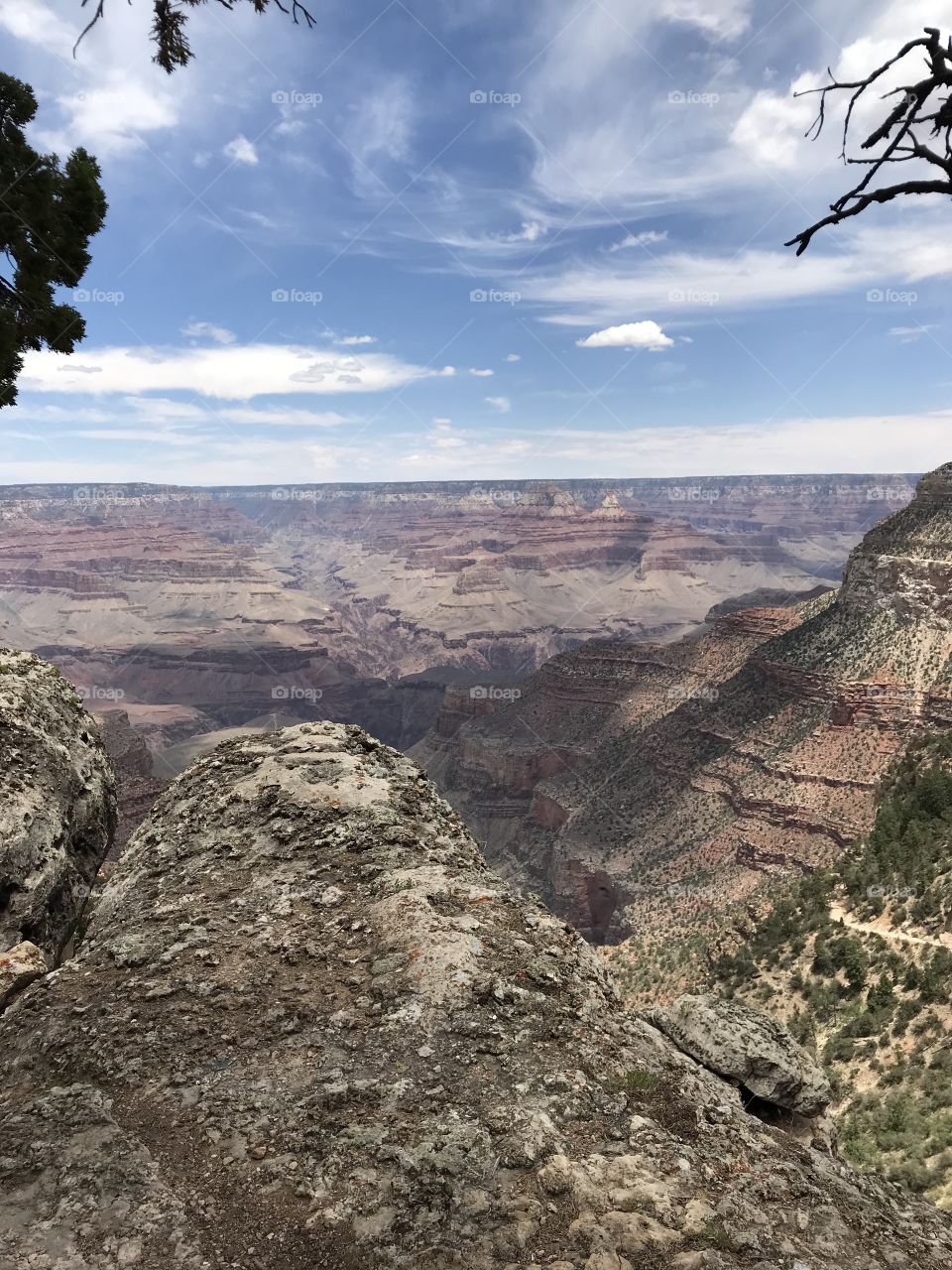 Looking over the edge into the expansive and beautiful rock formations of the Grand Canyon during midday. 