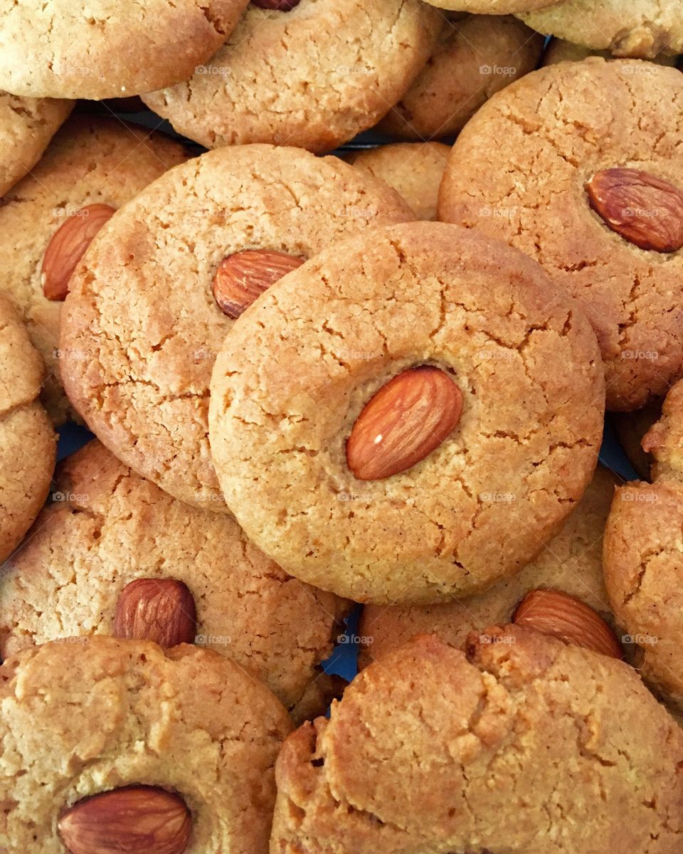 This is a close up photo of pile of golden honey almond cookies.