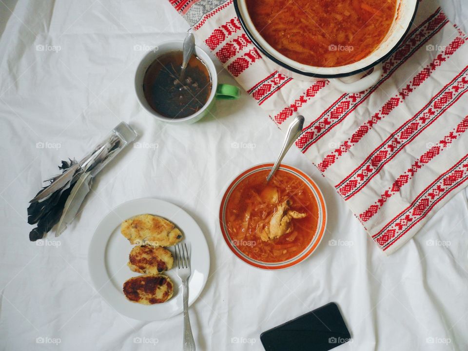 Ukrainian borscht, pies with meat and a cup of tea on the table