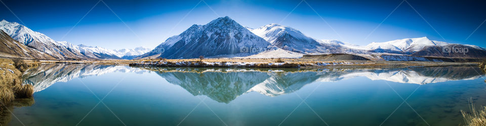 Mountains of the Ahuriri Valley reflected in the still waters of the Ahuriri river. Mackenzie Country, South Island, New Zealand