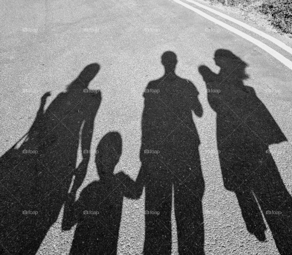 Shadow of a family out walking along a road
