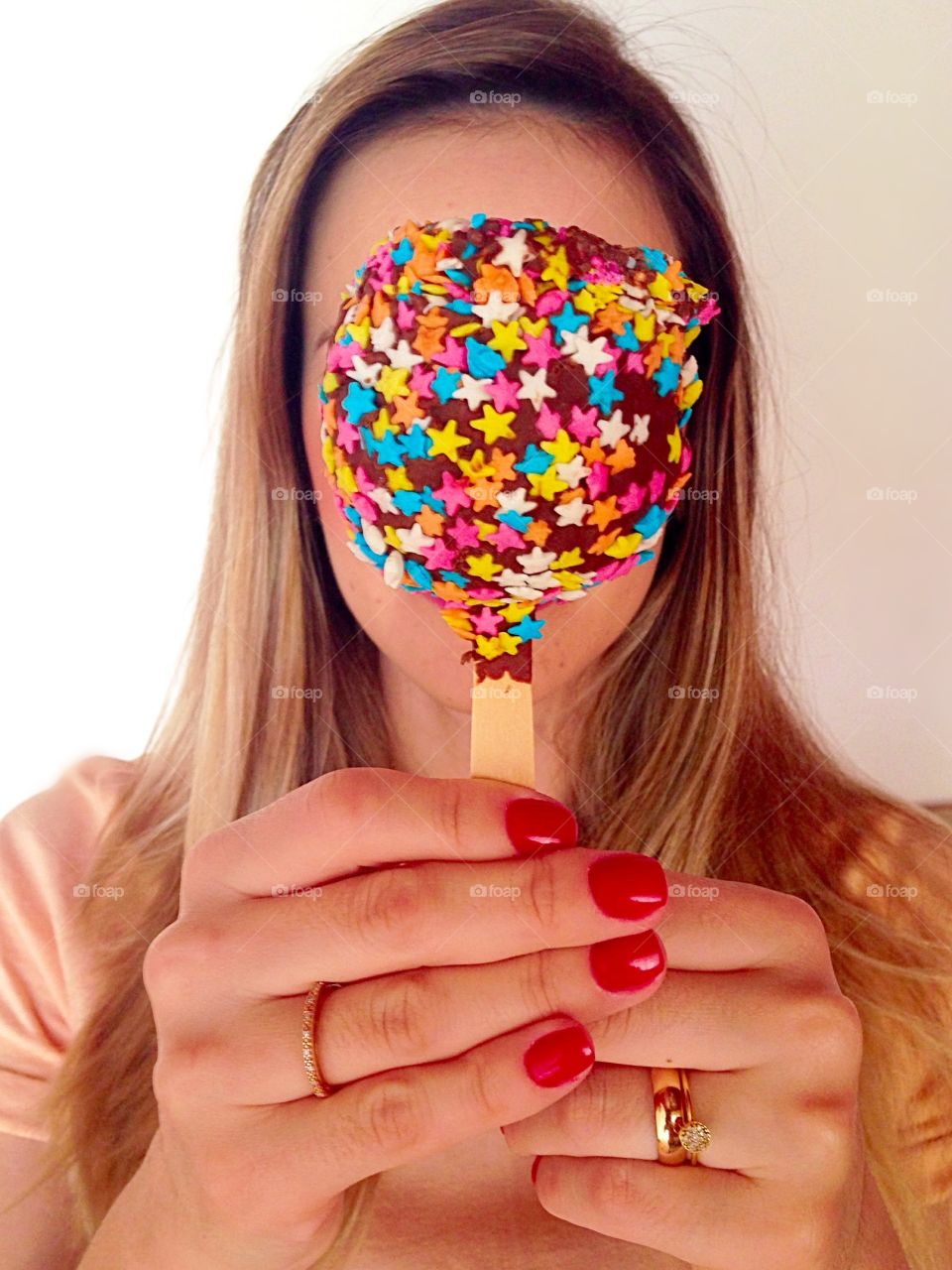 Woman holding candy in front of her face