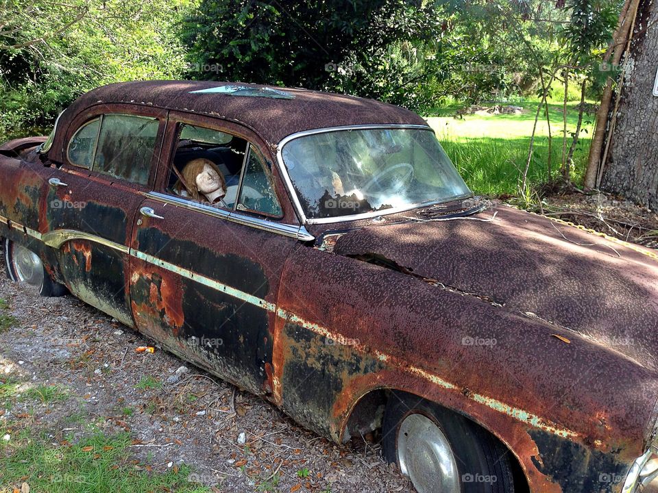 Rusty wrecked car with head inside, perfect imperfection 
