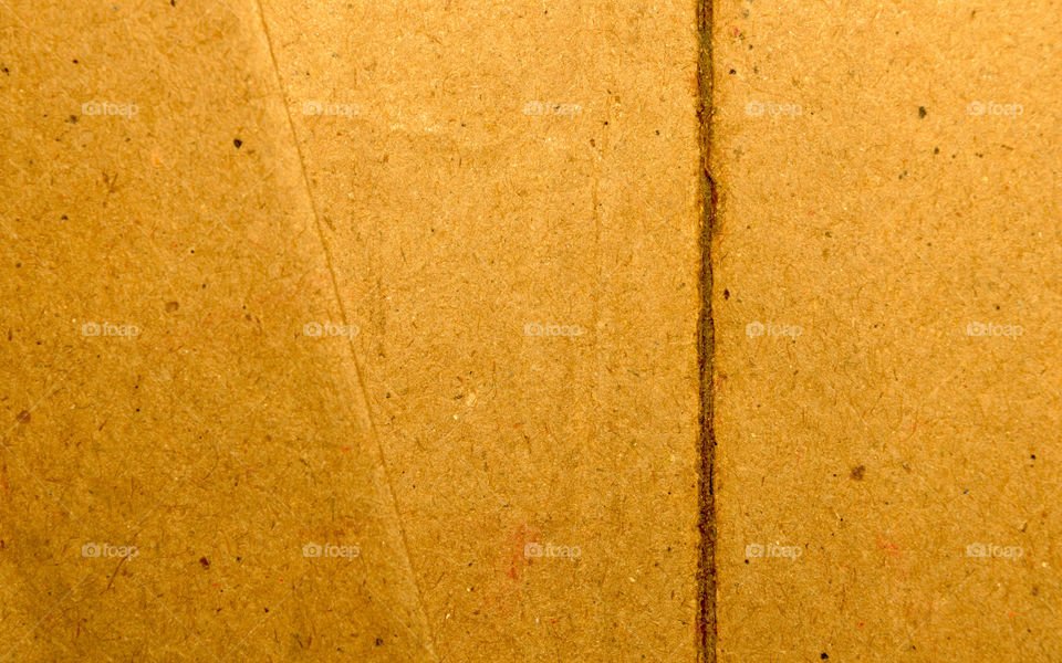 Surface of cut and torn sheet bright yellow color old vintage cardboard paper box. Abstract texture background close up. Natural canvas pattern background. Studio shot with copy space room for text.