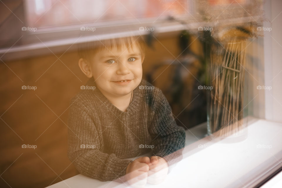 the boy looks out the window and smiles