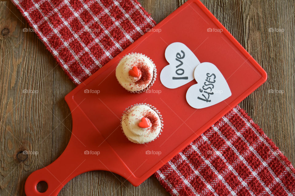 Red velvet cupcakes with Valentine's day sentiments on wood background