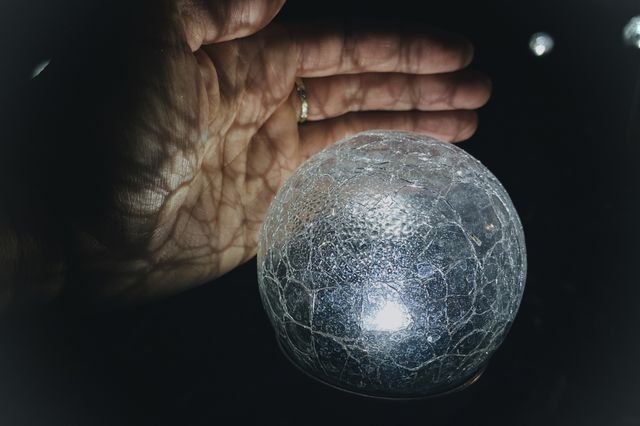 Crackle glass solar light casting its shadow on my hand. 