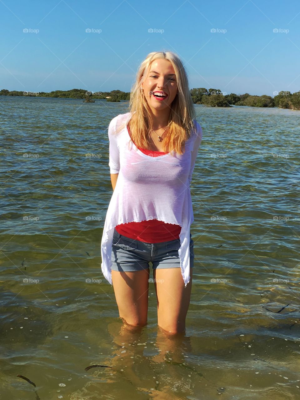 Smiling young woman standing in water