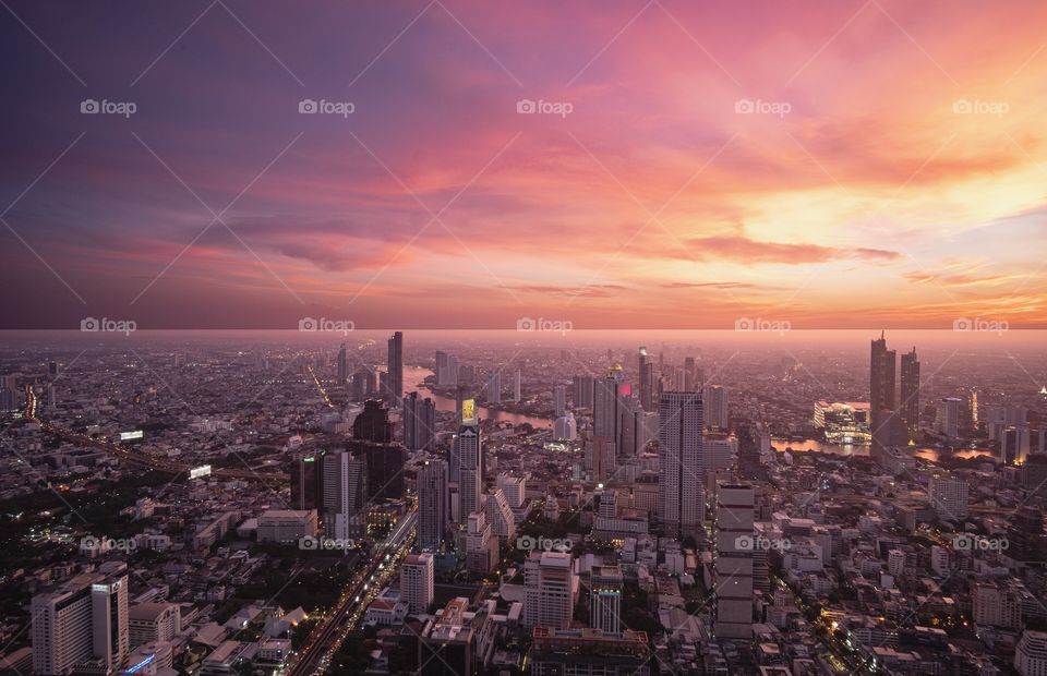 Bangkok/Thailand-June 22 2019:Beautiful light of Sunset shade over the Chao Phraya River and Building in the big city , take photo from MahaNakhon tower