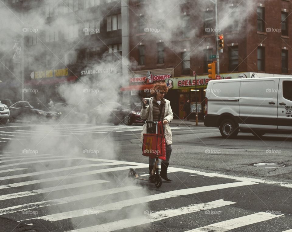 A lady with a scooter in the smoke 