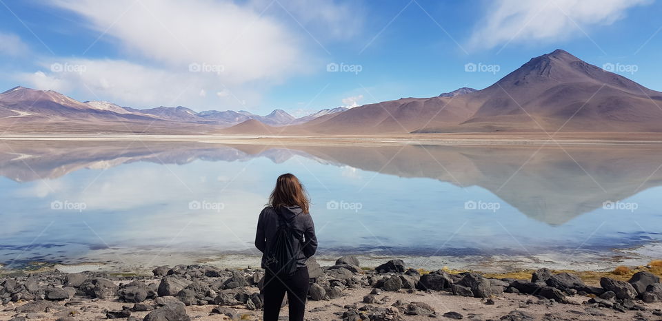 Woman enjoying the view over a mirror lake in Bolivia