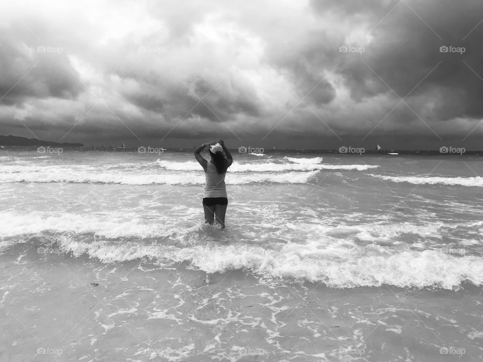 A free woman at the ocean facing the waves in her life.