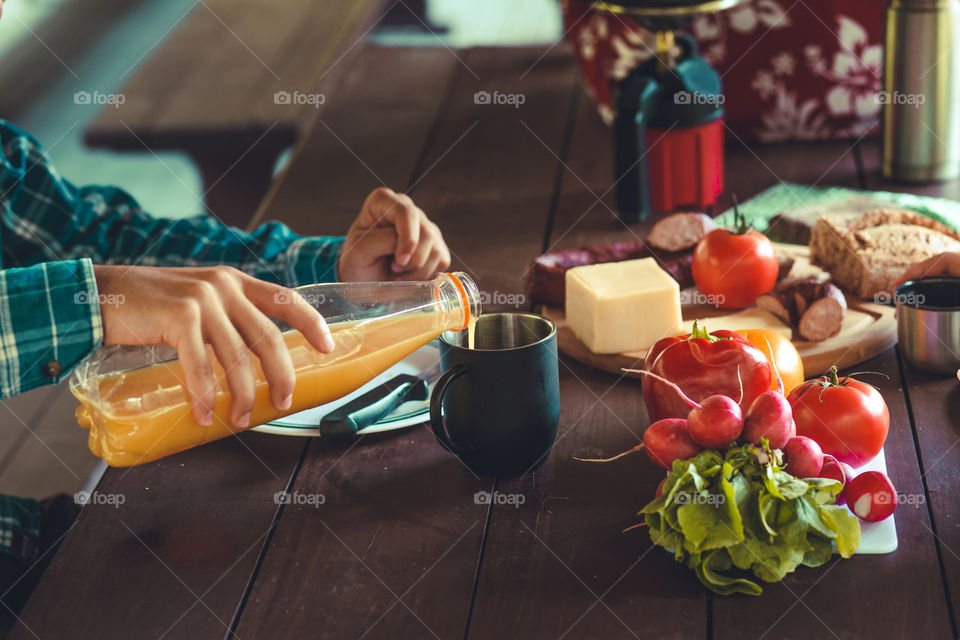 Preparing and eating a breakfast outdoor during spending vacation on camping