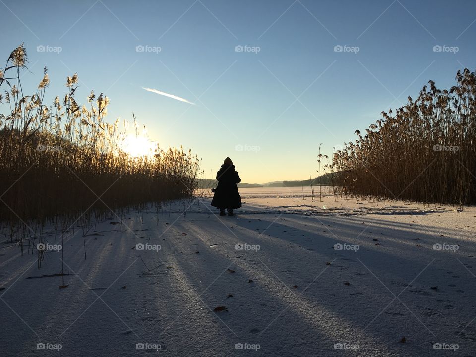 Young person standing on snow and watching the nature