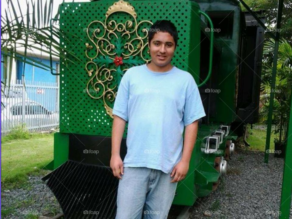 Teen posing  in front of a train.