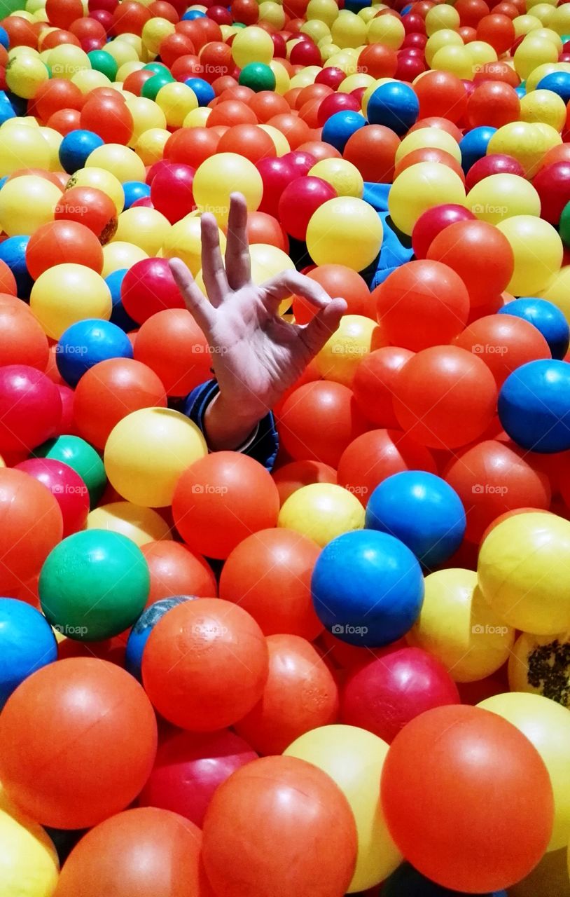 a ball pond and one hand rising saying everything is right, ok