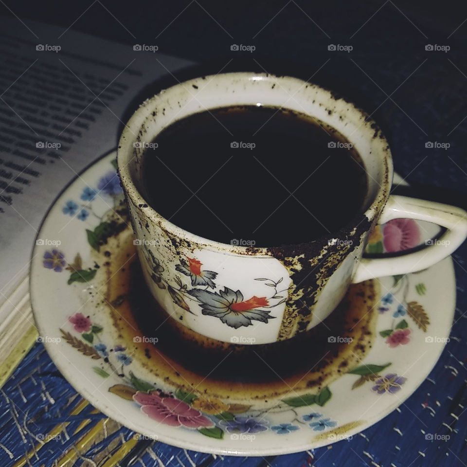 A cup of coffee next to a book