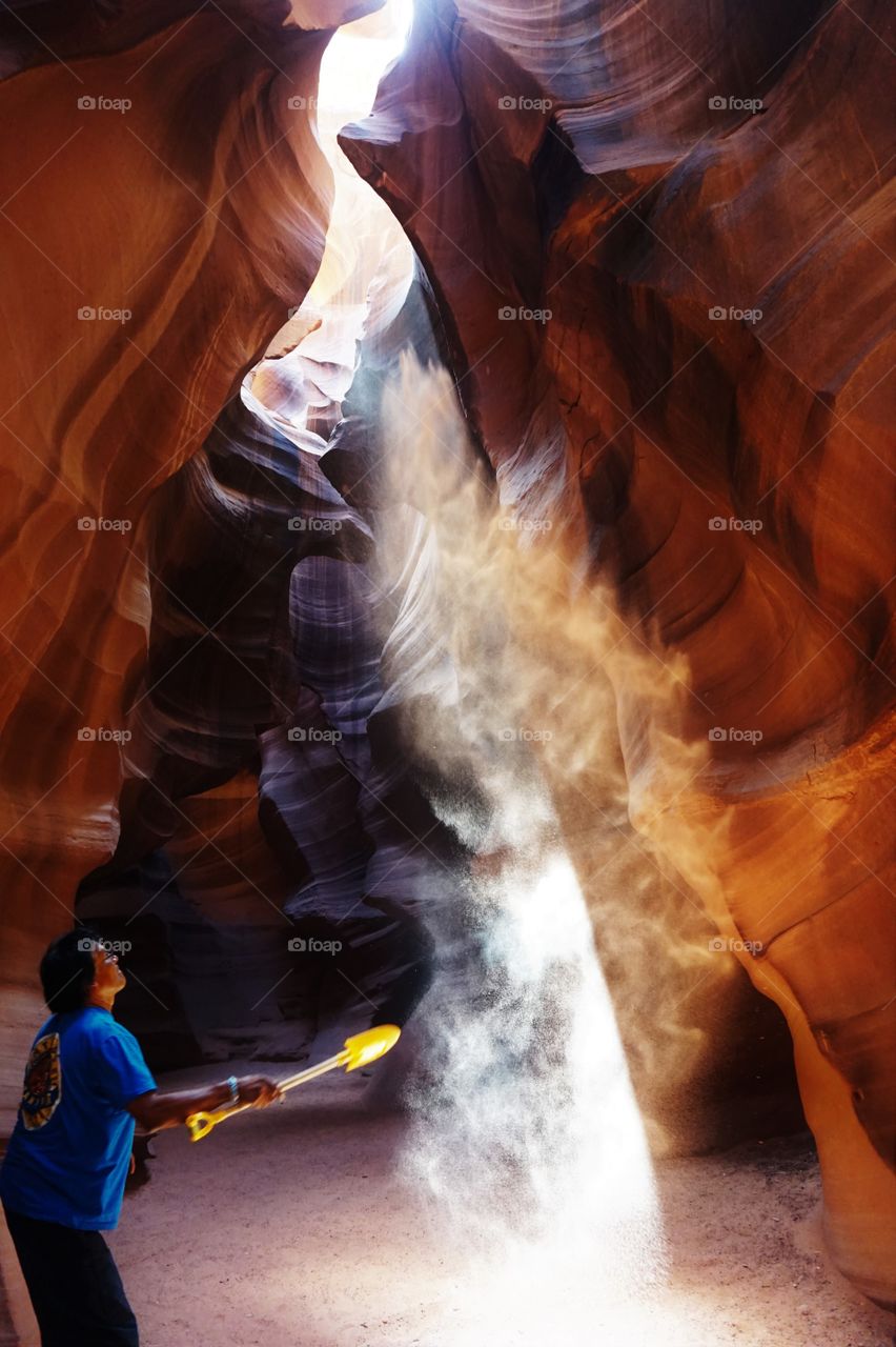 a light reflected on the sand trow in the air make shape of a visible ray of light in a canyon