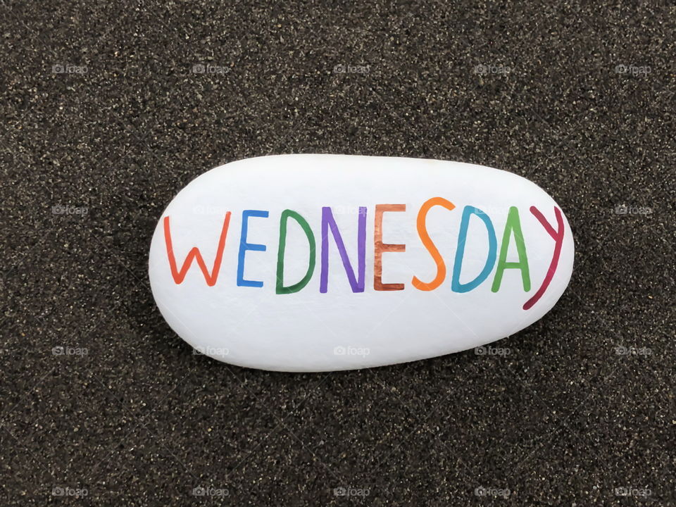 Wednesday, third day of the week text carved and painted on a stone over black volcanic sand
