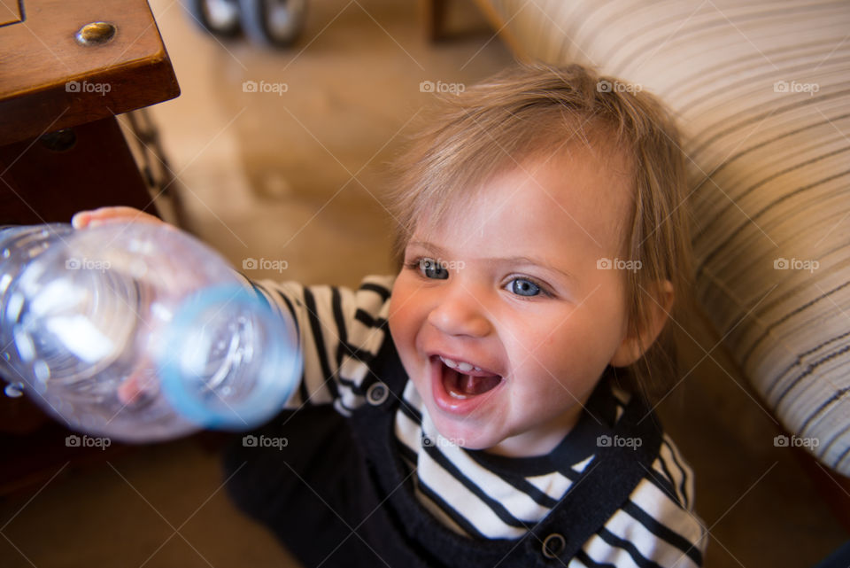 High angle view of a baby girl holding bottle