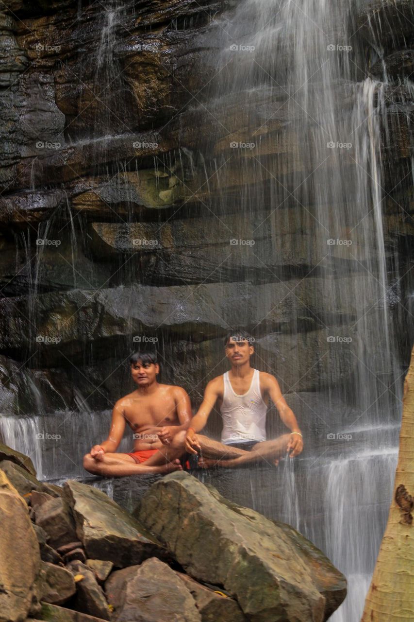 Sitting under a waterfall in summer 