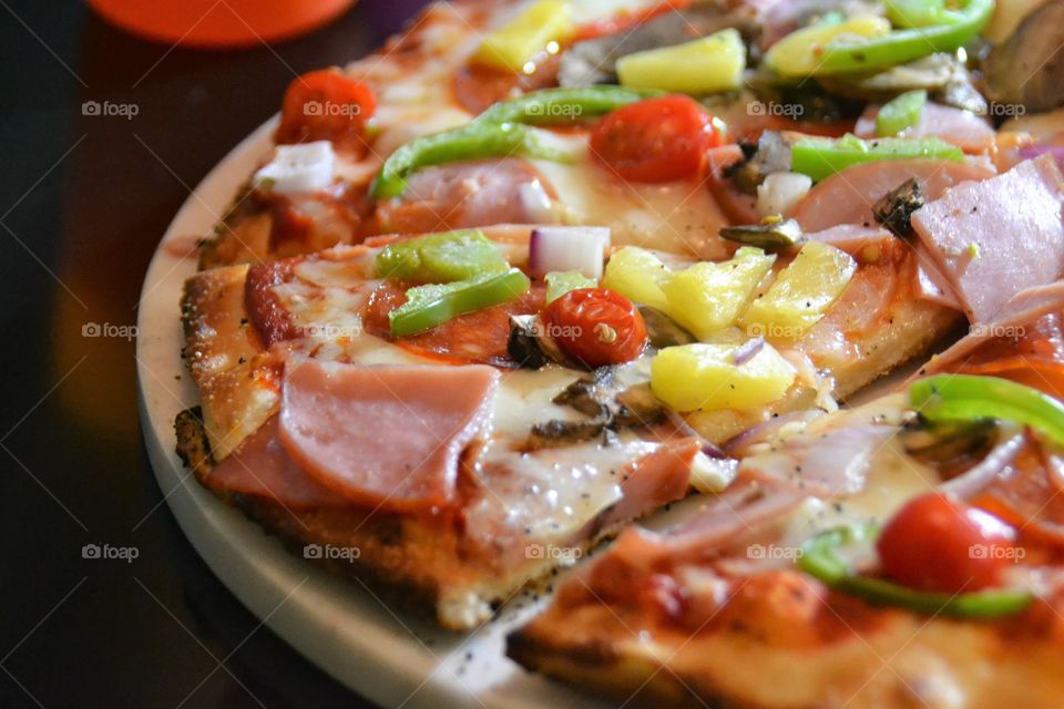 Pizza with veggies meat an pineapple 