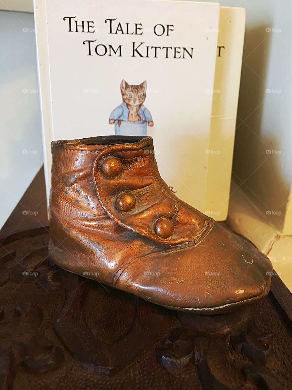 Bronzed vintage baby shoe and Beatrix potter book