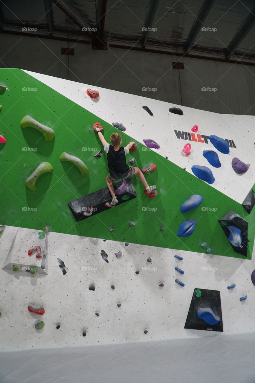 Boy climbing a bouldering wall