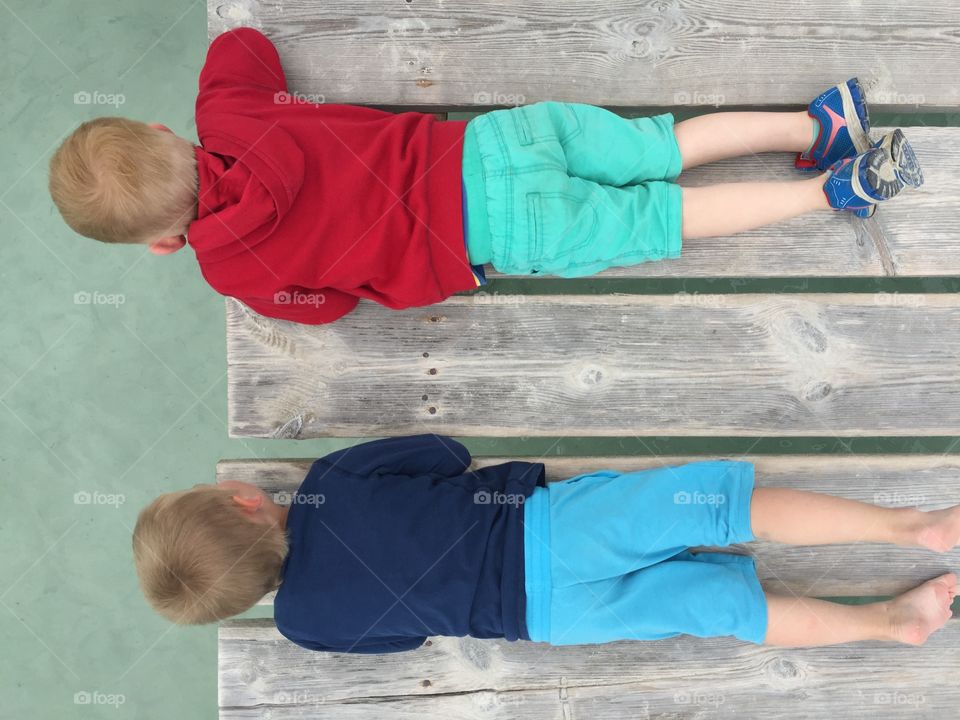 High angle view of children lying on pier