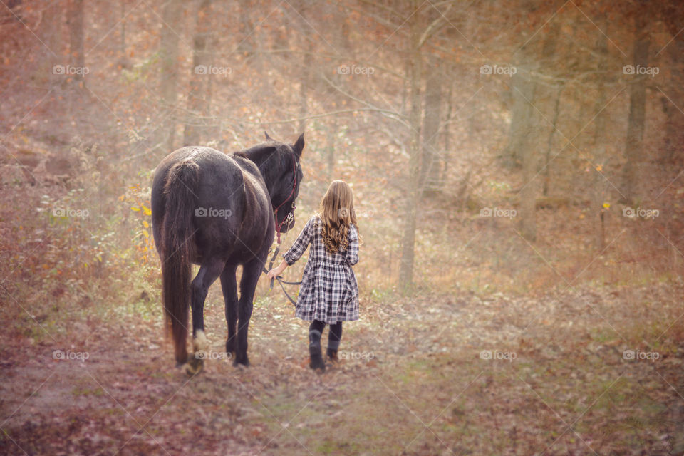 Young Girl Walking Her Black Horse
