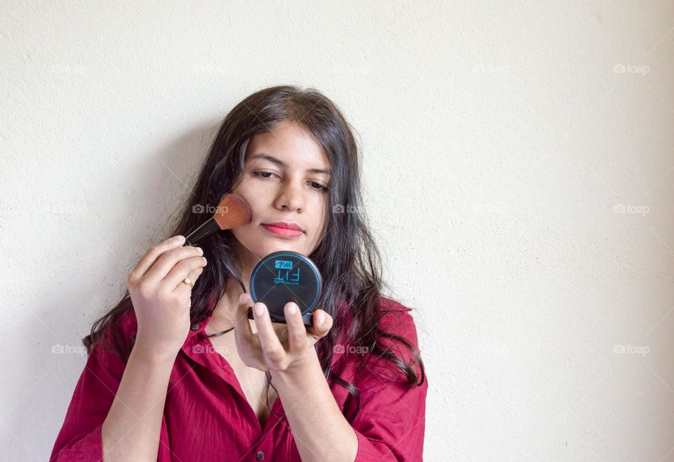 Woman applying compact powder.