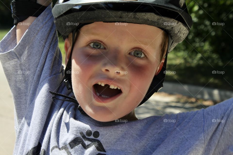 Darling photo of young boy excited to get his blades, elbow pads and helmet back on for the summer!!