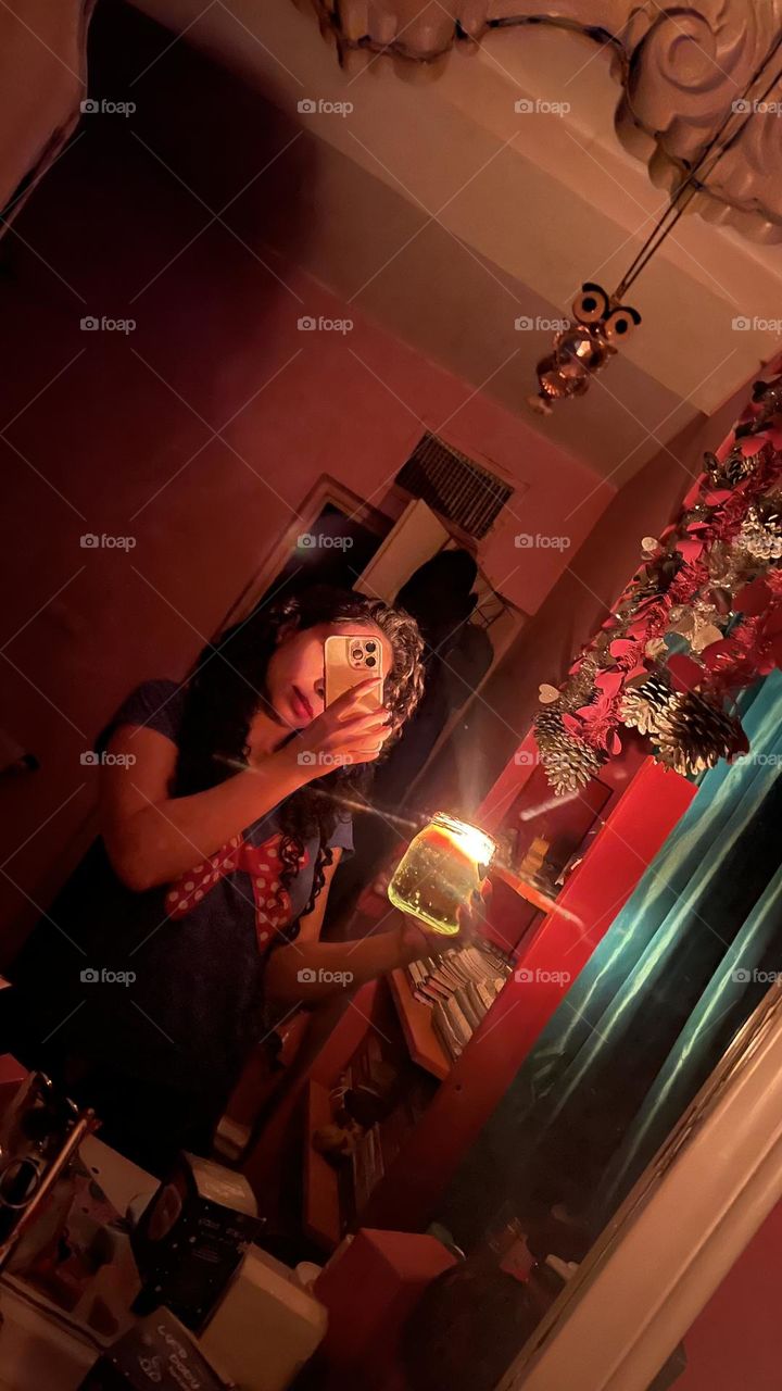 Curly haired girl in a dark room with candlelight