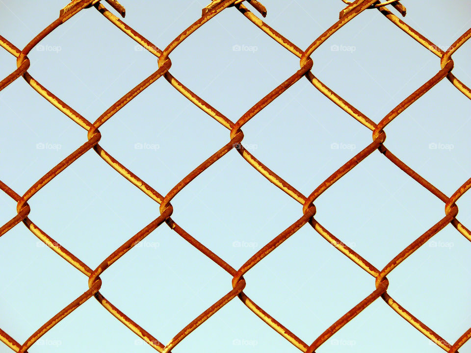 Close-up of fence against clear blue sky in Berlin, Germany.