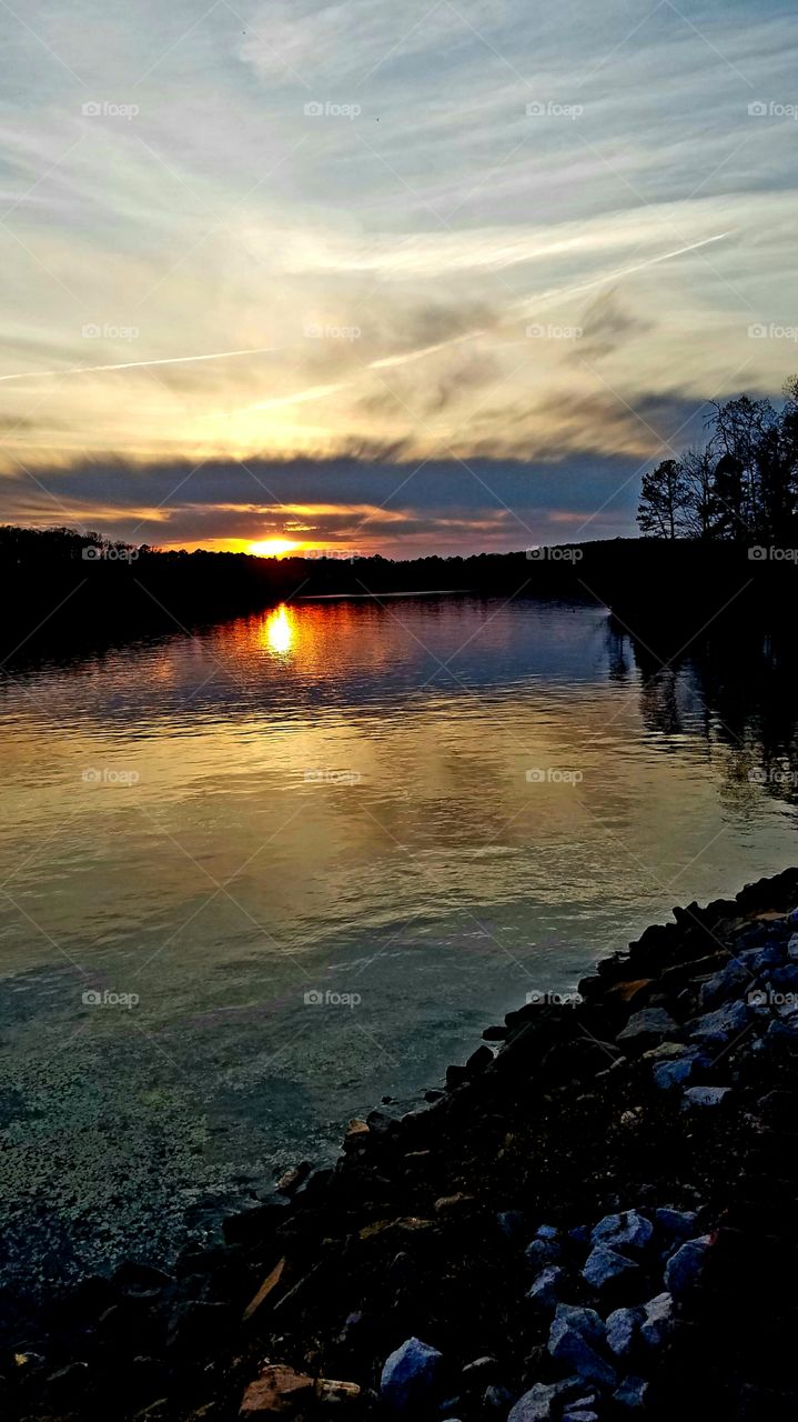 yellow to purple sunset with pollen on the lake