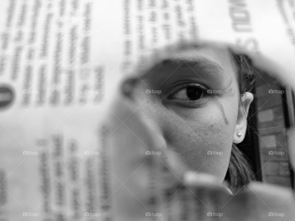 Girl looking through newspaper