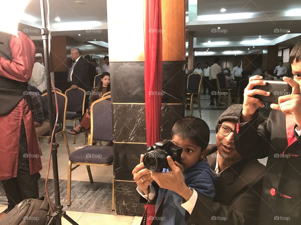 People taking photograph with camera and mobile phone in an event