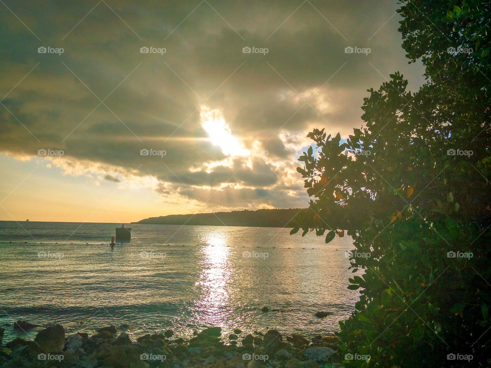 beautiful view a the sun shining through the clouds at the beach sun🌅🌥🏖