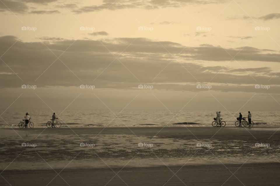 People riding bicycles on the beach