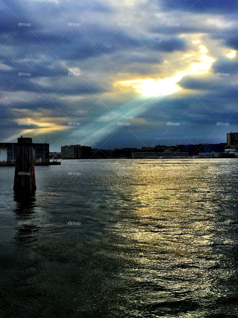 Beam of light shines down on the Hudson River, New York City.. Beam of light shines down on the Hudson River, New York City. iPhone photo.