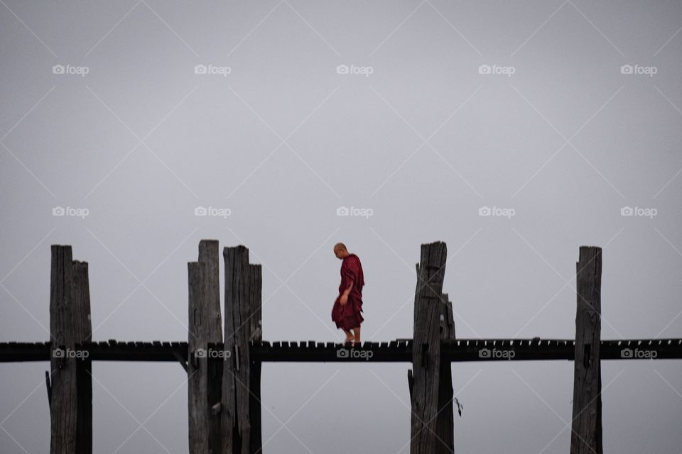 Myanmar local life style ,Monk is  walking to temple on U being bridge , the most longest wooden bridge in the world