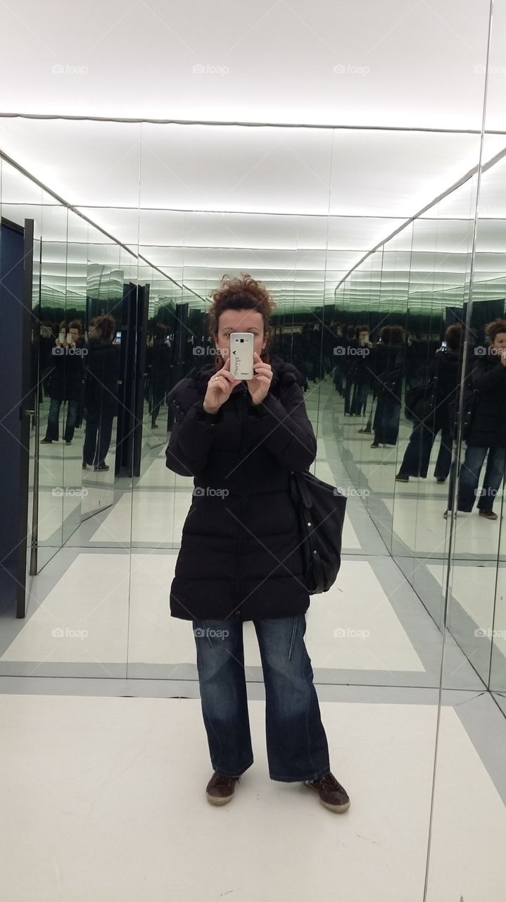Woman with mobile phone in front of glass wall